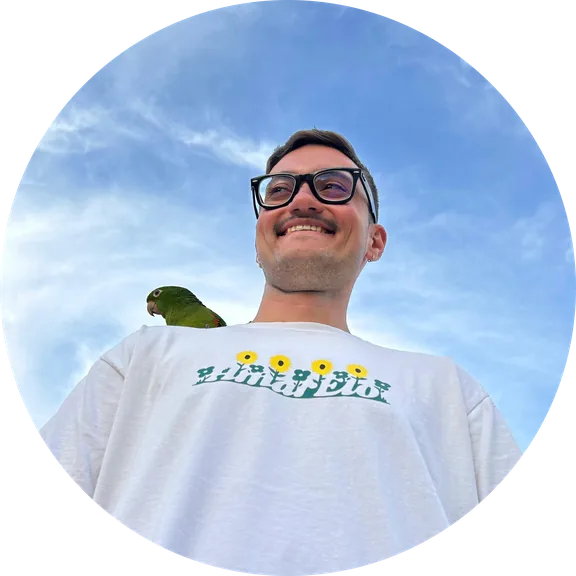 Felipe Lamarca smiling, with a parrot perched on one shoulder